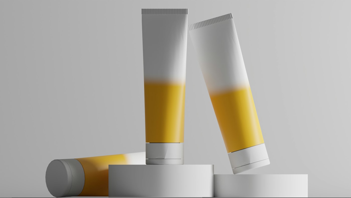 Two white and yellow squeeze tubes balanced on round plinths